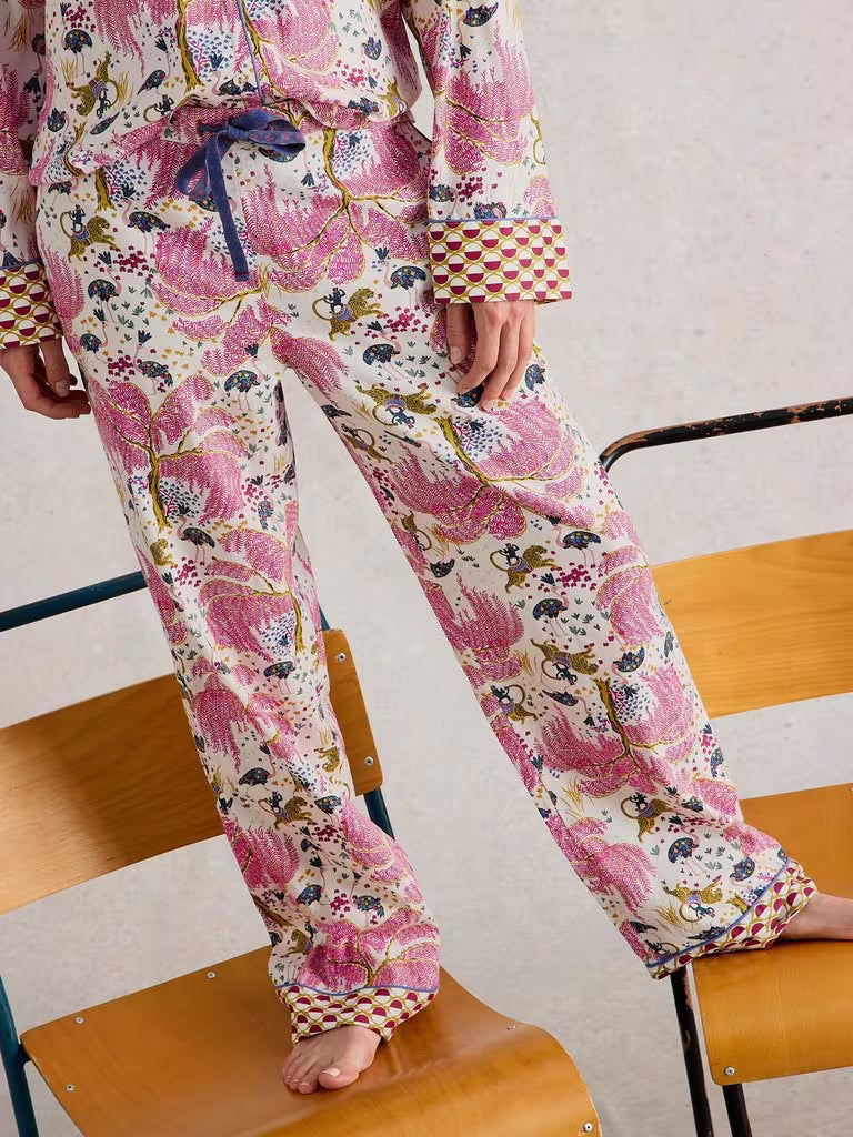 White Stuff Organic Nina PJ Bottom Natural White Stuff Clothing womens pyjama bottoms Person wearing a colorful floral pajama set sitting on a chair.