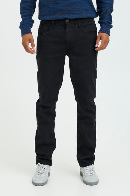 Blend Jeans Twister Fit Denim Black Regular/Slim Fit jeans for men with a Regular Waist and Zip fly. Colour: Rosin Material: 81% Cotton, 17% Polyester & 2% Elastane Person wearing black pants and a blue top on a white background