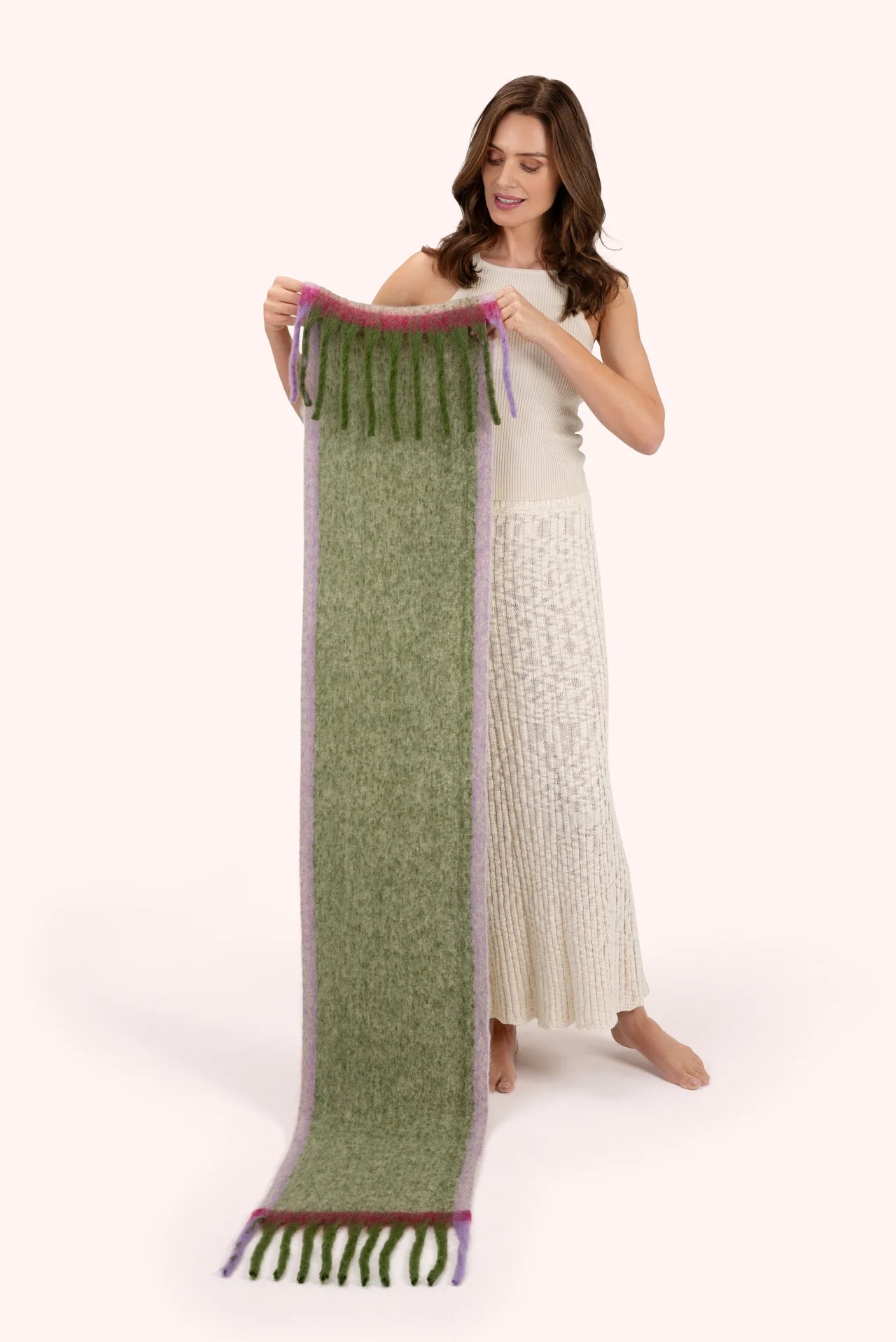 Powder Aria Cosy Scarf Sage Powder accessories womens scarf Woman holding a long green scarf with purple accents on a white background