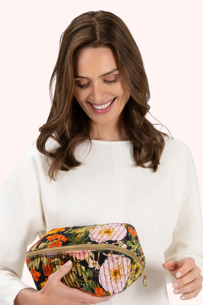 Powder Quilted Make Up Bag Midnight Posy Powder Accessories womens makeup bag velvet bag Woman holding a floral clutch bag against a white background