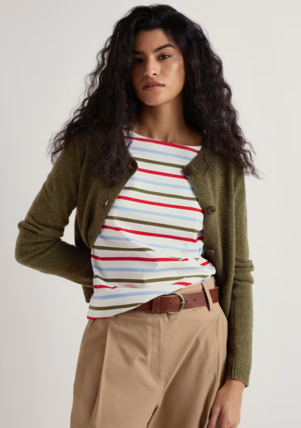 Seasalt Tern Tide Cardigan Seagrass womens Semi fitted with a Crew neck that's Button fastening and Ribbed hem and cuffs with Ribbed neckline that should be Hand Wash In Cold Water Colour: Seagrass Material: 60% Merino Wool & 40% Nylon Woman wearing a striped shirt, green cardigan, and beige pants on a white background