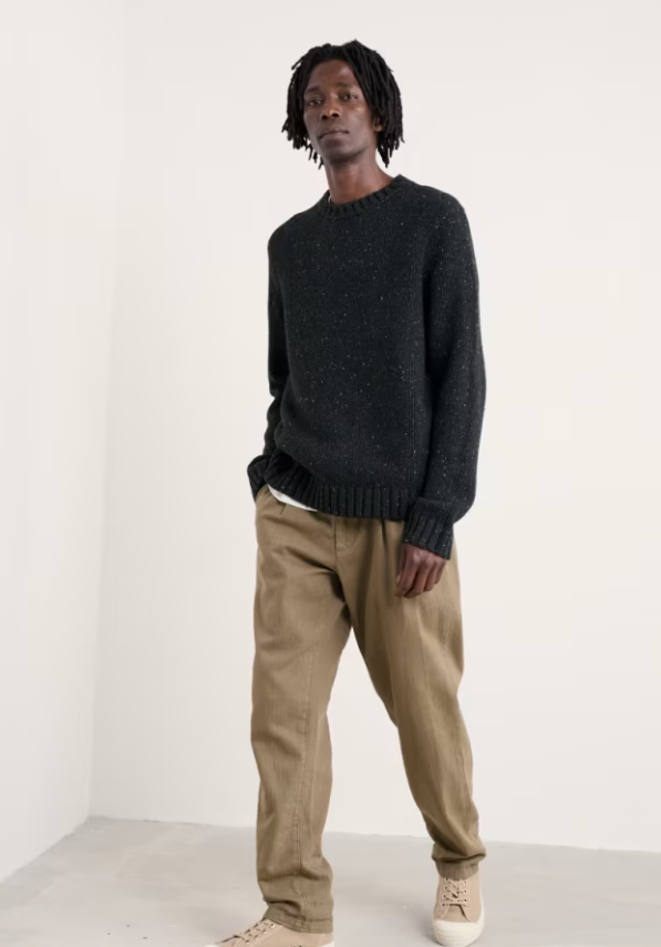 Seasalt Men's Bizen Jumper Onyx Mens Jumper Mens Wool Jumper Seasalt clothing Man wearing a dark sweater and beige pants against a white background