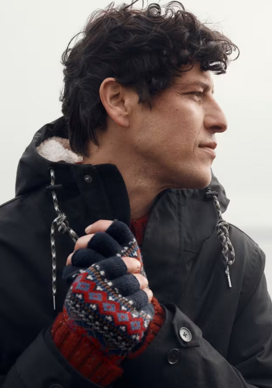 Seasalt Men's Gunvor Fair Isle Fingerless Gloves Sparnon Multi Mens Gloves Seasalt clothing Man wearing a black coat and patterned gloves against a neutral background