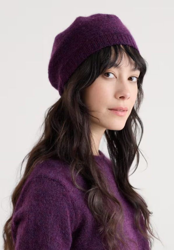 Seasalt Needle Tip Mohair Blend Beret Grape Seasalt Hat Seasalt Clothing Person wearing a purple beanie and sweater against a white background
