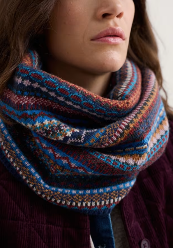 Seasalt Touchstone Snood Star Jasmine Coal Jetty Mix Seasalt clothing womens snood Close-up of a person wearing a colorful patterned scarf.