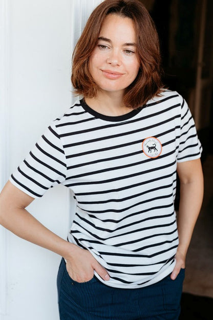 Sugarhill Brighton Maggie T-shirt Off White / Black Lucky Cat womens Signature shape with Crew neck that's Machine washable (delicate) Colour: Off White / Black Lucky Cat Material: 100% Organic Cotton Woman wearing a black and white striped t-shirt with a small logo.