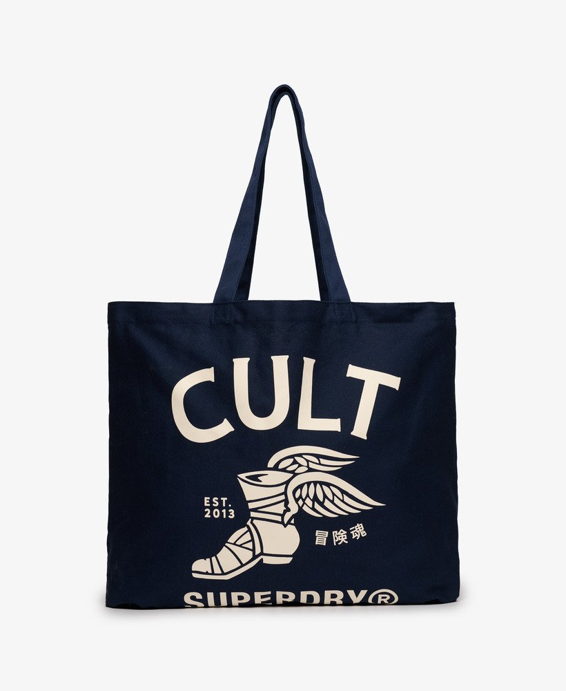 Superdry Cult Tote Richest Navy/Off White Retro Cult Tote Bag Colour: Richest Navy/Off White Material: 100% Cotton Style Code: W9110444A Colour Code: G1N Navy tote bag with 'CULT' and 'Superdry' branding on a white background