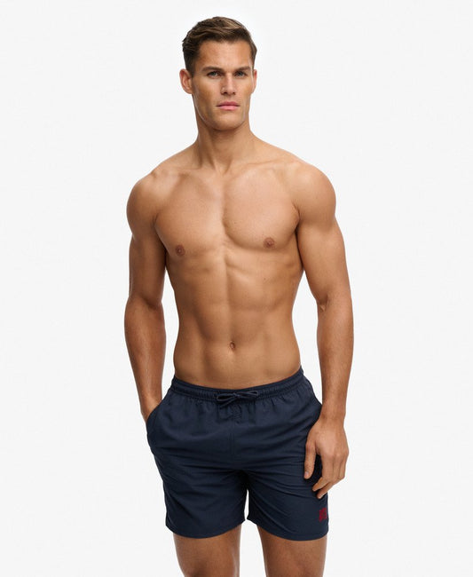 Superdry Essential 16-inch Swim Shorts Nautical Navy Mens Relaxed fit shorts with Lower rise with an internal mesh lining and Two external side pockets with an adjustable drawcord and an elasticated waist Colour: Nautical Navy Material: 100% Recycled Polyester Man wearing navy swim shorts on a white background