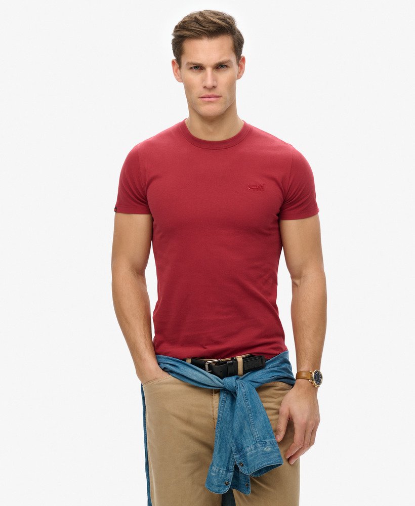 Superdry Essential Logo T-Shirt League Red mens Buy 3 Essential Logo T-Shirts For £50 a Sim fit – designed to fit closer to the body for a more tailored look that's Ribbed crew neckline with Short sleeves and Embroidered logo Colour: League Red Material: 100% Organic Cotton Style Code: M1011245A Man wearing a red t-shirt and beige pants with a white background