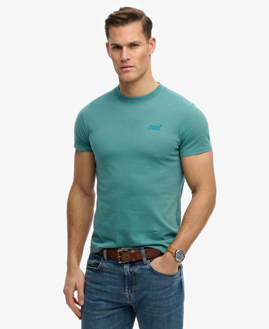 Superdry Essential Logo T-Shirt Teal mens Buy 3 Essential Logo T-Shirts For £50 a Sim fit – designed to fit closer to the body for a more tailored look that's Ribbed crew neckline with Short sleeves and Embroidered logo Colour: Teal Man wearing a teal t-shirt and jeans on a white background