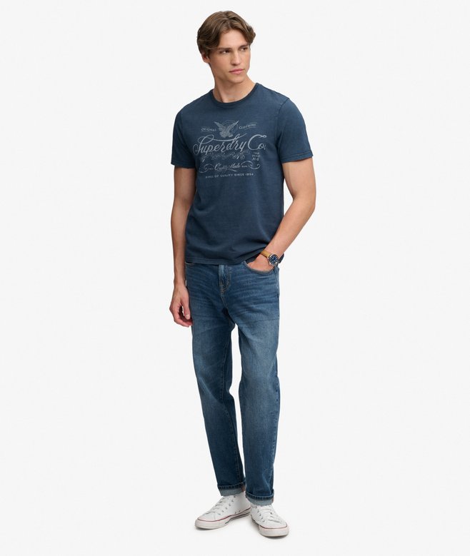 Superdry Mercantile Men's T-Shirt Eclipse Navy. Wit a Relaxed fit Ribbed crew neckline and short sleeves with Distressed trims and Printed graphic across chest Material: 100% Organic Cotton Style Code: M1012434A Colour Code: 98T