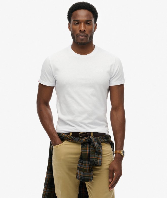 Superdry Organic Cotton Essential Logo T-Shirt Optic Buy 3 Essential Logo T-Shirts For £50 a mens Sim fit – designed to fit closer to the body for a more tailored look that's Ribbed crew neckline with Short sleeves and Embroidered logo Colour: Optic Man wearing a white t-shirt, beige pants, and a plaid shirt over his shoulders on a white background