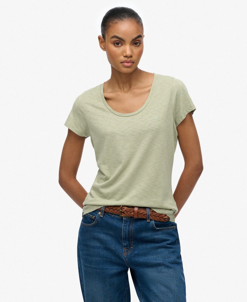 Superdry Studios Scoop Neck T-Shirt Dusty Sage womens Buy 3 Studio or Slub T-Shirts For £50 Material: 60% Cotton & 40% Lyocell Relaxed fit – the classic Superdry fit. Not too slim, not too loose, just right. Go for your normal size with a Scoop neck and Short sleeves that's Embroidered Superdry logo Colour: Dusty Sage Woman wearing a light green t-shirt and blue jeans on a white background
