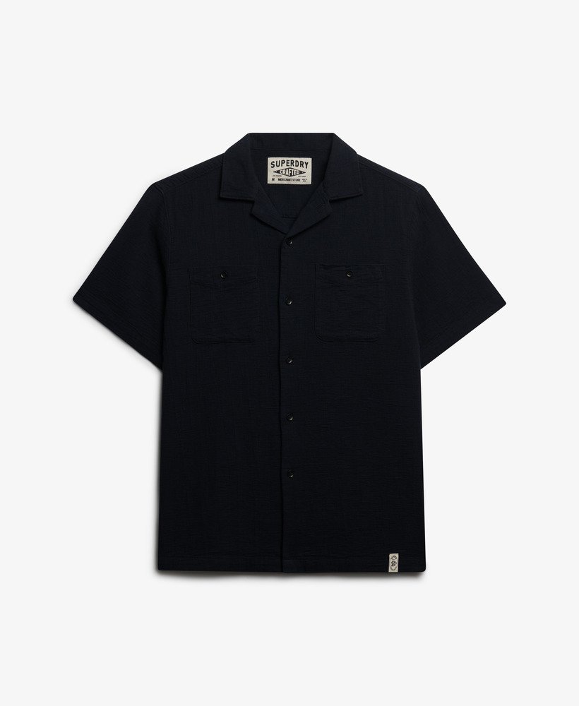 Superdry Textured Short Sleeve Shirt Black mens Relaxed fit with Single collar with button fastening Two chest pockets with button fastening Colour: Black Material: 100% Organic Cotton Style Code: M4011123A Black short-sleeve shirt with a brand label on a white background