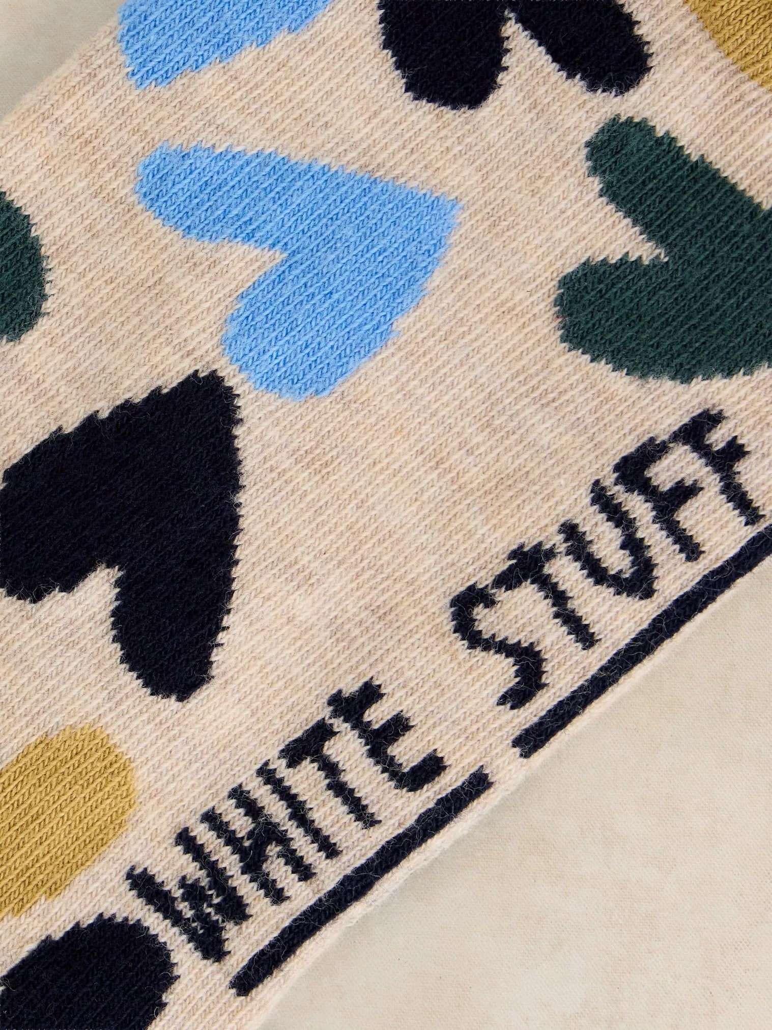 Close-up of a product with colorful abstract patterns and 'White Stuff' branding.