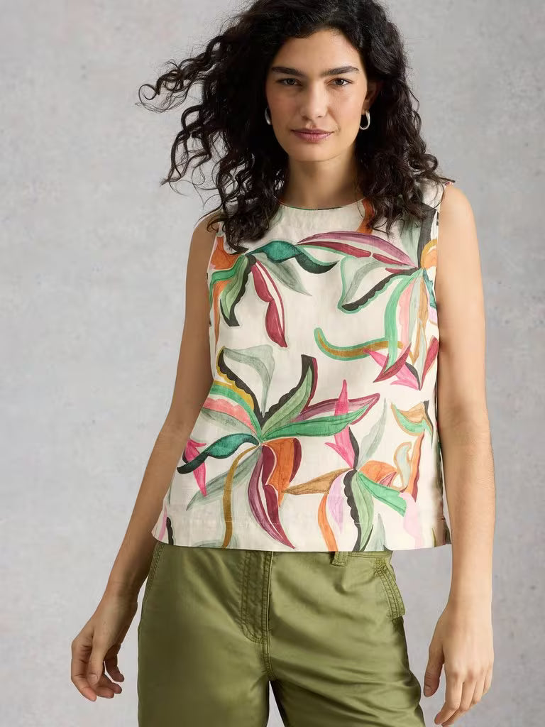 White Stuff Matilda Linen Vest Natural Print for women. Crew Neck that's Sleeveless and a Classic Fit that's Machine Washable. Material: 100% Linen Style Code: 446092  Woman wearing a sleeveless top with colorful leaf pattern against a plain background