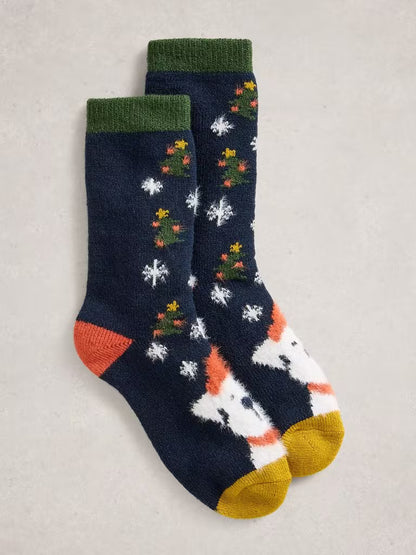 White Stuff Christmas Dog Cabin Socks Womens Socks White Stuff clothing Fluffy Christmas Dog socks Pair of festive socks with Christmas tree and snowflake patterns on a neutral background