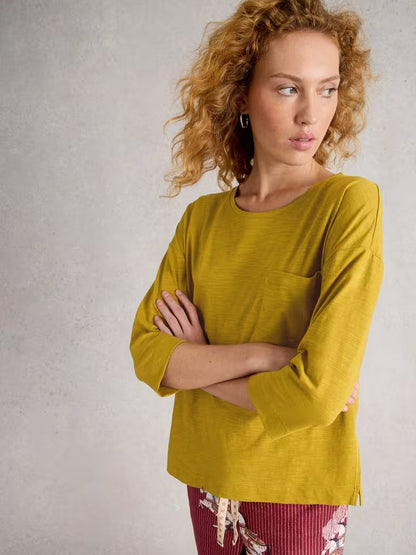 White Stuff Mia Boxy Tee Mid Chartreuse Womens tee White Stuff Clothing Woman wearing a mustard yellow long-sleeve top against a neutral background
